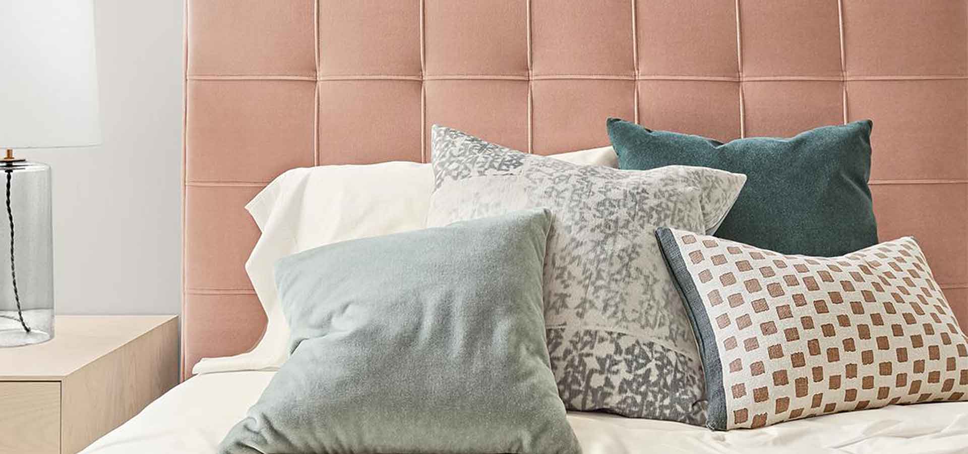 Millennial pink upholstered bed with pillows