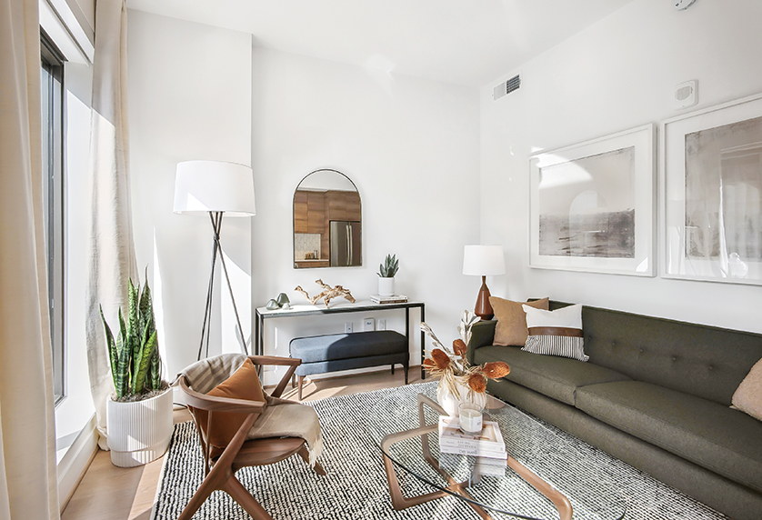 Living room of REVA apartment with Andre sofa, Soren lounge chair, Dunn coffee table, Parsons console tale, Infinity mirror, Tri-Plex floor lamp, Cloak table lamp and Chantal Talbot wall art.